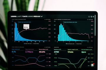 Dark analytics dashboard with blue and green charts on a computer screen