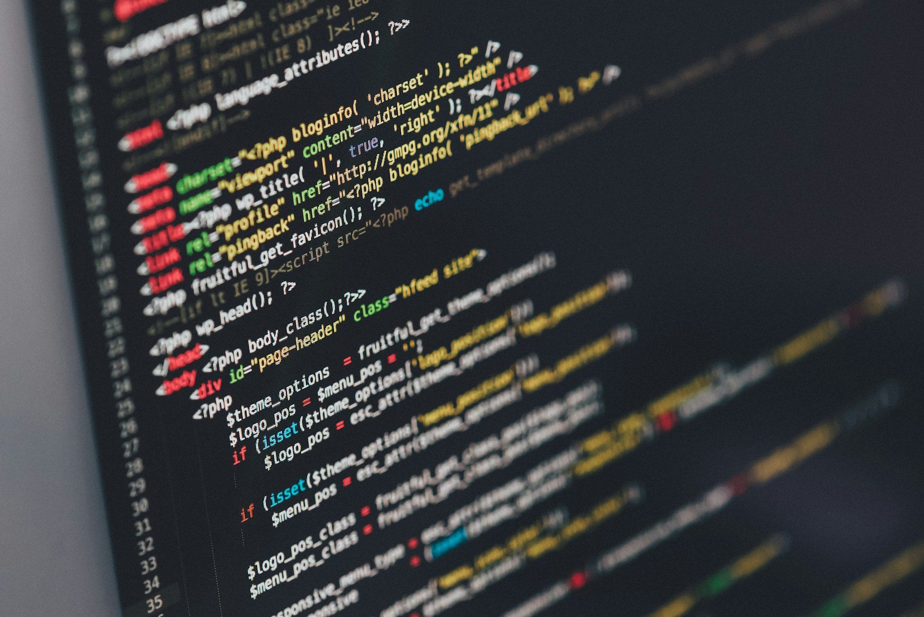 Close-up of colorful code on a computer screen in a dark setting