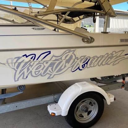 A white boat with the word wet dream on the side is on a trailer — Cairns Custom T-Shirts In Cairns City, QLD