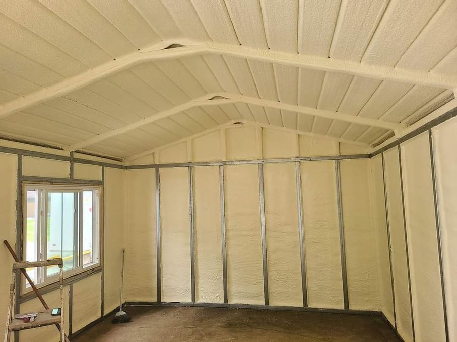 Interior of a white insulated room under construction, with exposed framing and a window opening.