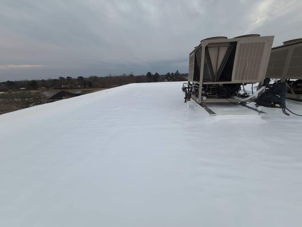 Snow-covered rooftop with HVAC units under an overcast sky