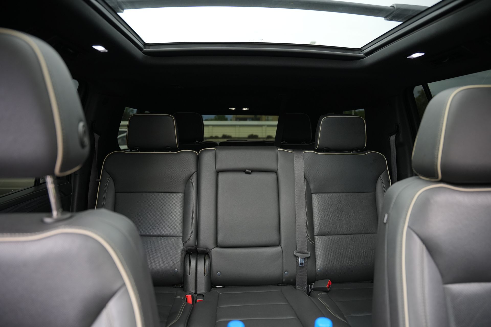Rear seats and cabin of a black SUV, viewed from the front, with a sunroof and headrests visible