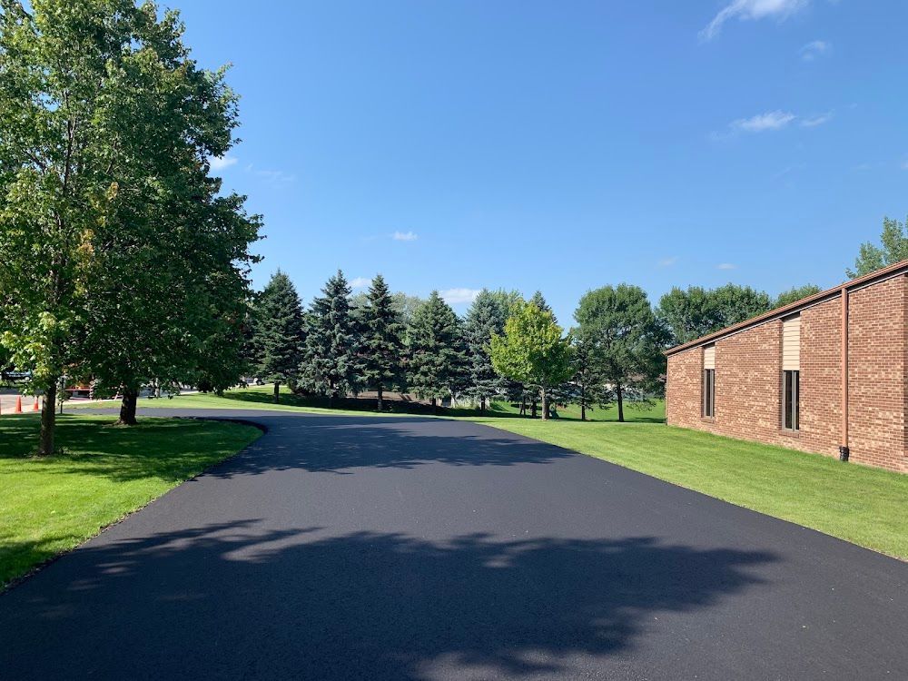 Freshly installed asphalt driveway surface in a residential northern Iowa neighbourhood.