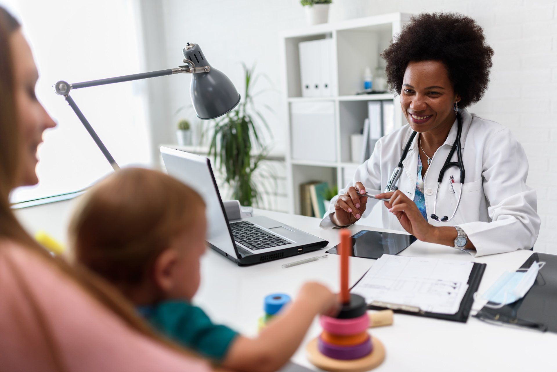 Doctor smiling at patient and child in office.