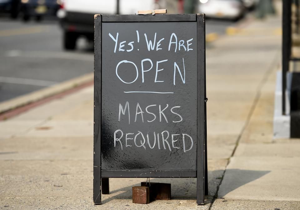Black chalkboard sign on sidewalk: