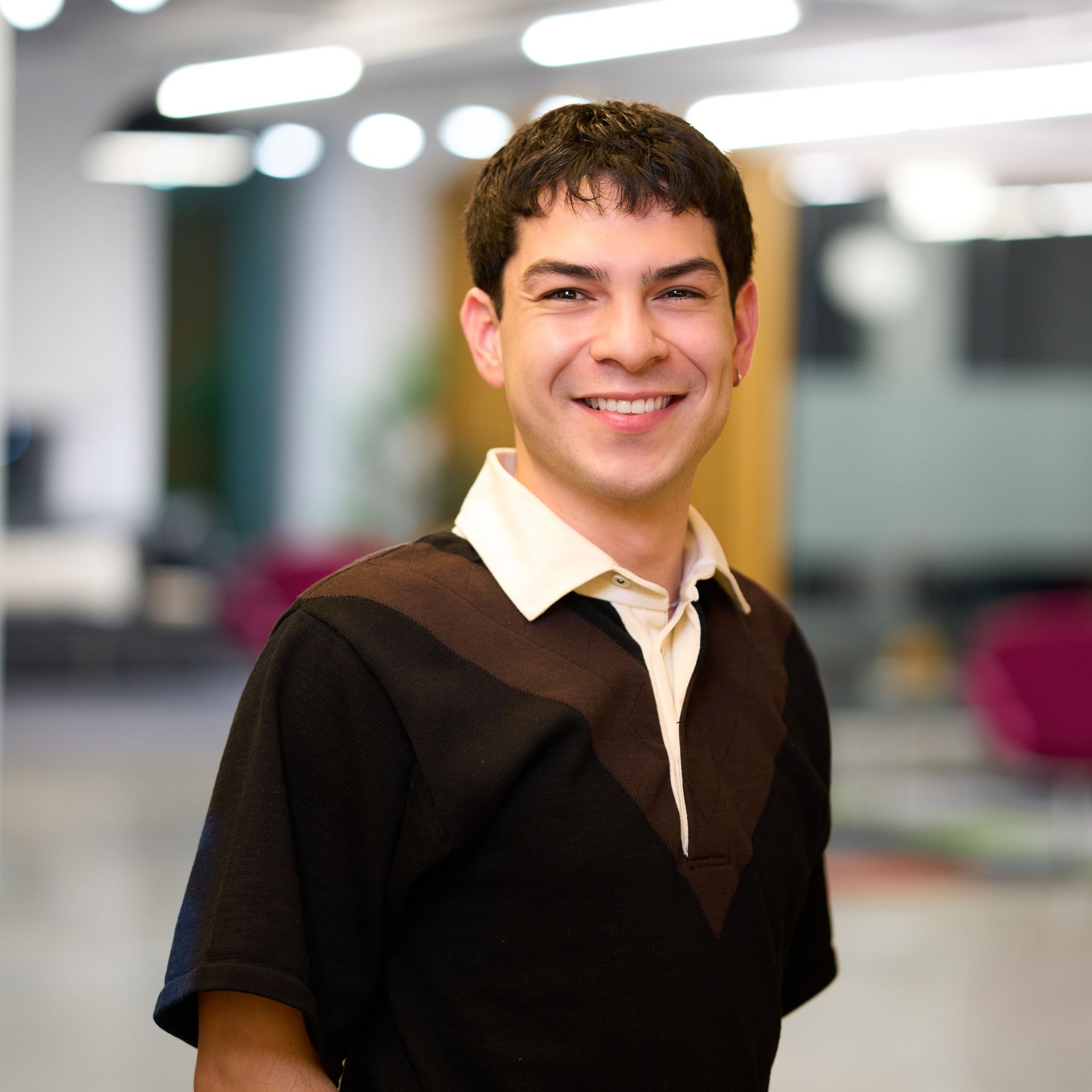 Man smiling wearing a black and brown shirt