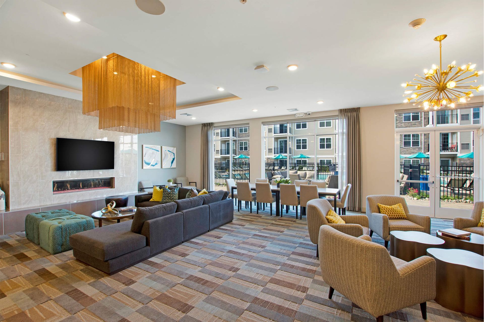 Spacious community lounge with a large sectional, armchairs, TV, and a fireplace at The Parc at Roxbury in  Roxbury, NJ.