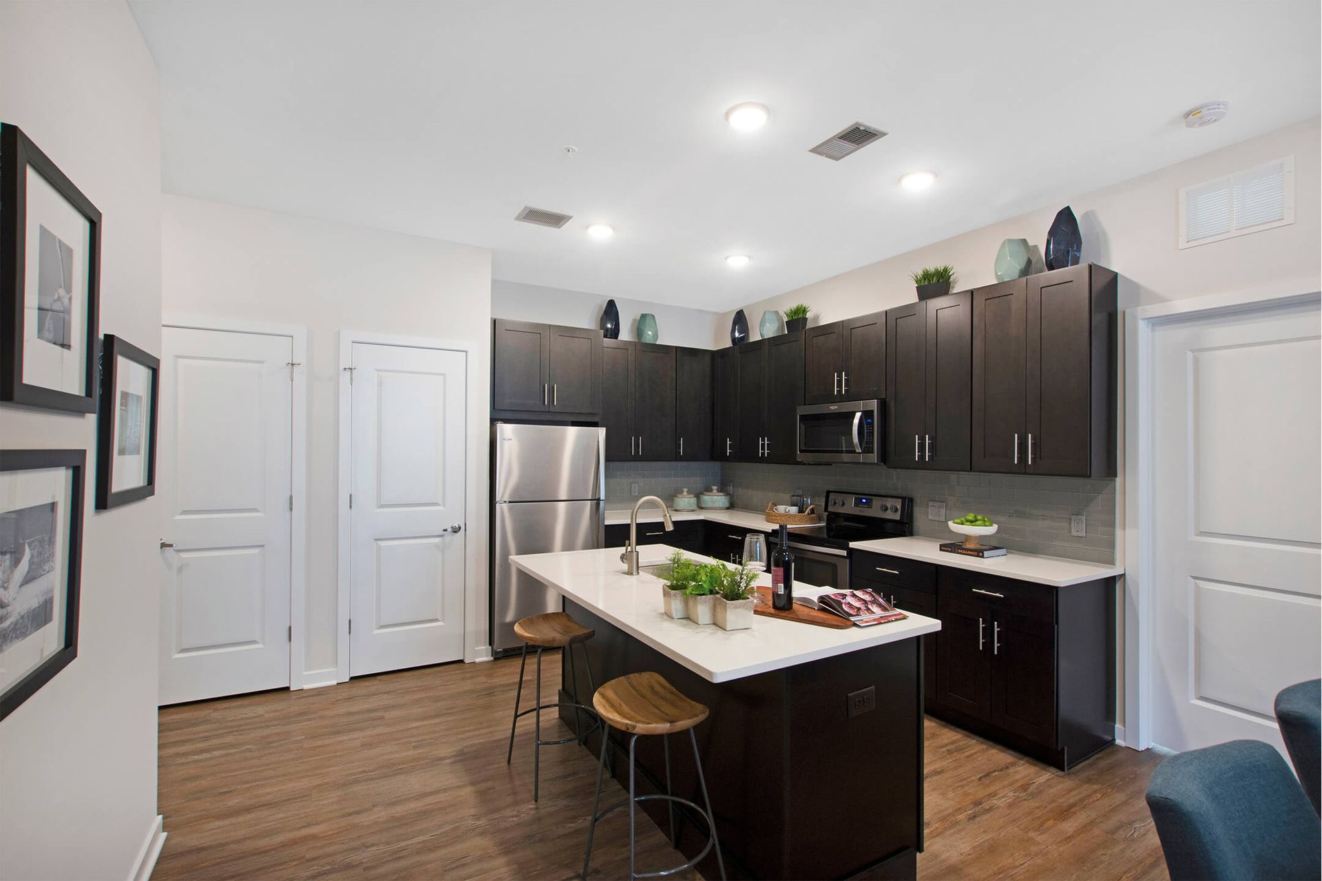 Modern apartment kitchen with dark cabinets, stainless appliances, and a central island at The Parc at Roxbury in  Roxbury, NJ.