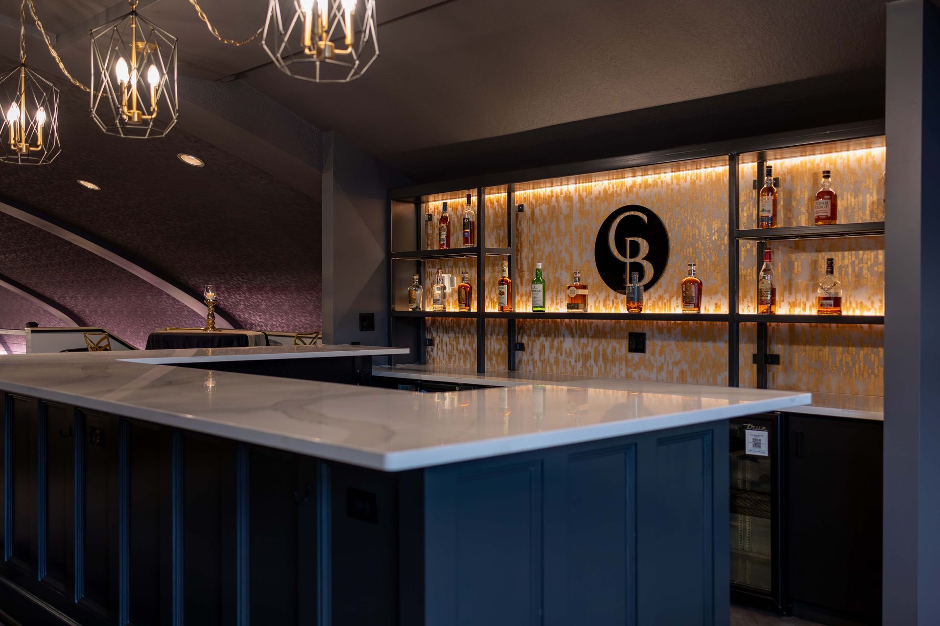 A bar with a lot of bottles of alcohol on shelves.