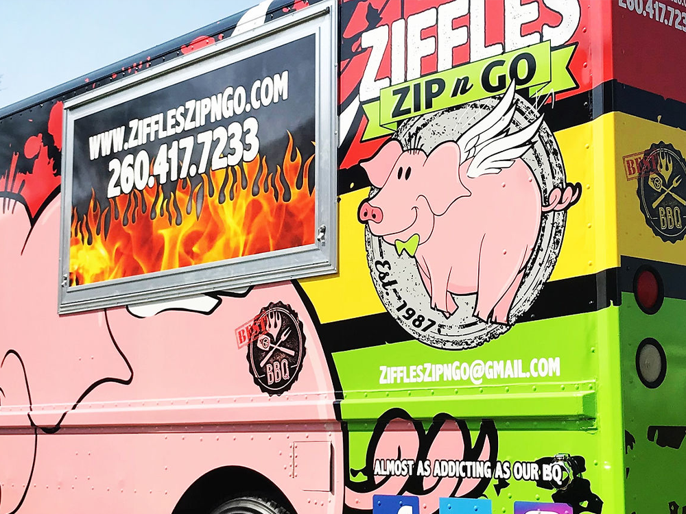 A food truck with a picture of a pig on it