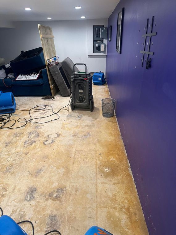 Hair salon interior with styling stations, mirrors, counters, and blue floor fan on a dark floor