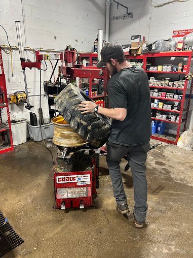 Worker sing a Coats Rim Clamp Tire Changer | Tire City Auto Repair