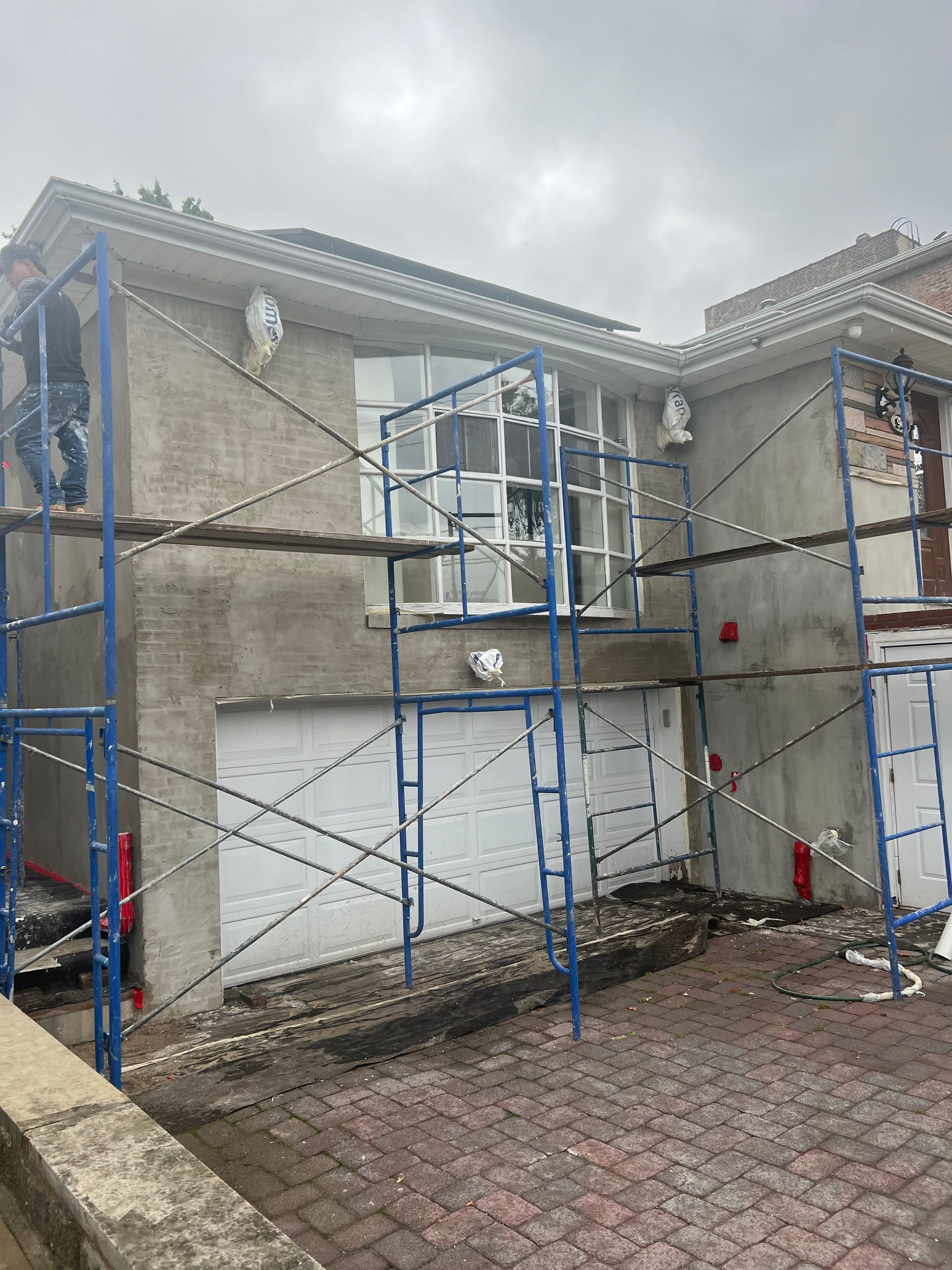 House exterior with scaffolding and white-trimmed windows under construction