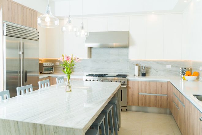 A person in a white apron is working in a kitchen