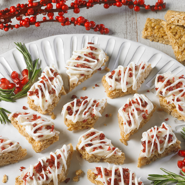 granola bars halved and topped with cream cheese and cranberries on a white serving tray