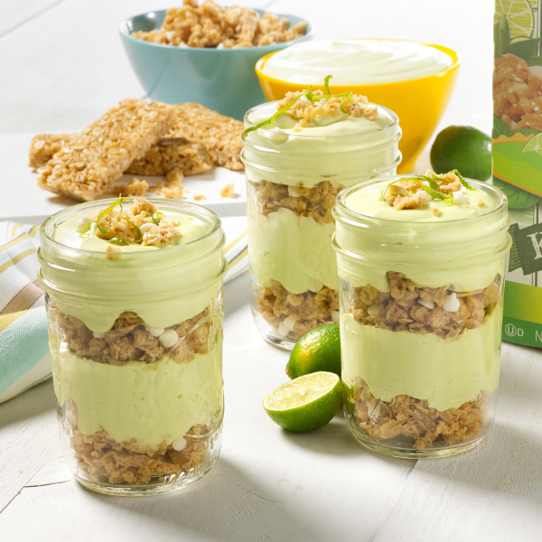 key lime parfaits layered with granola, key lime filling on a white background
