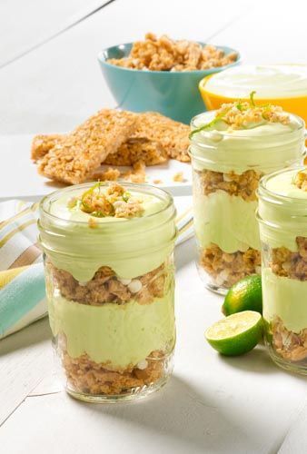 key lime parfaits layered with granola, key lime filling on a white background 