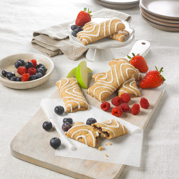 image of stacked soft baked bars on a white background with fresh fruit