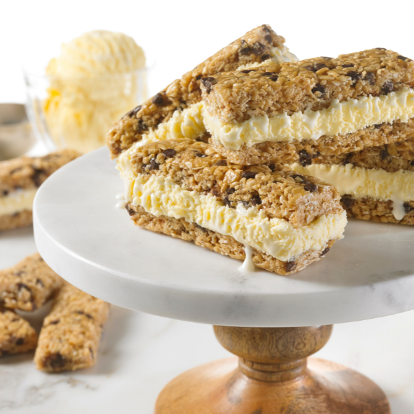 chocolate chip granola bars sandwiching vanilla ice cream on white plate