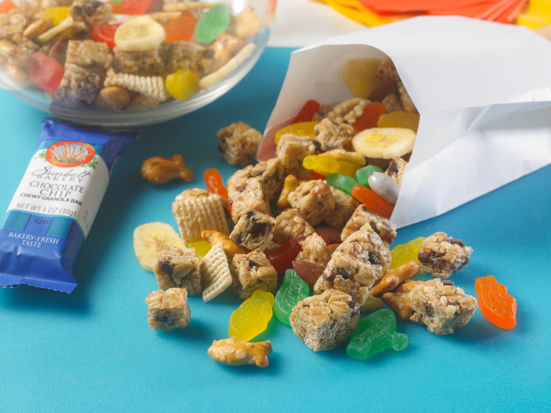 trail mix made of granola, fish gummies, chex cereal, fish pretzels and banana chips spilling out of white bag
