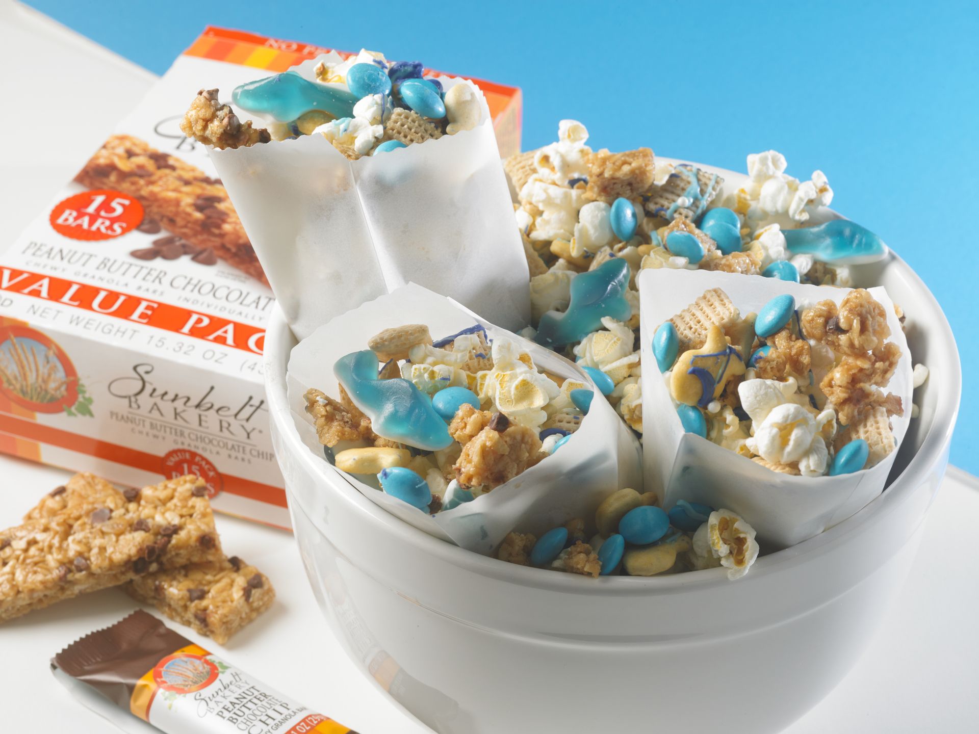 granola mix made of popcorn, chex cereal, fish crackers and shark gummies in white bags