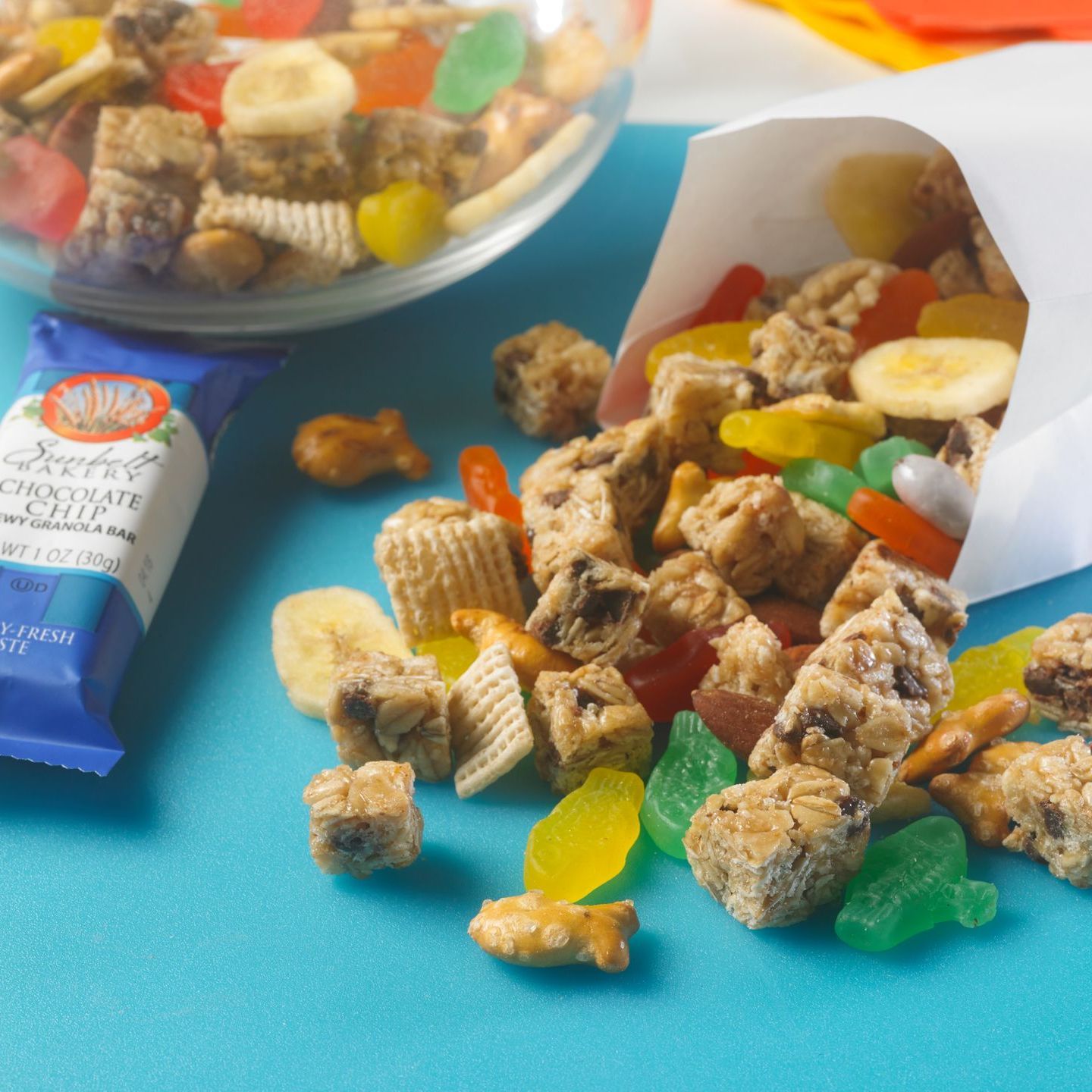 trail mix made of granola, fish gummies, chex cereal, fish pretzels and banana chips spilling out of white bag