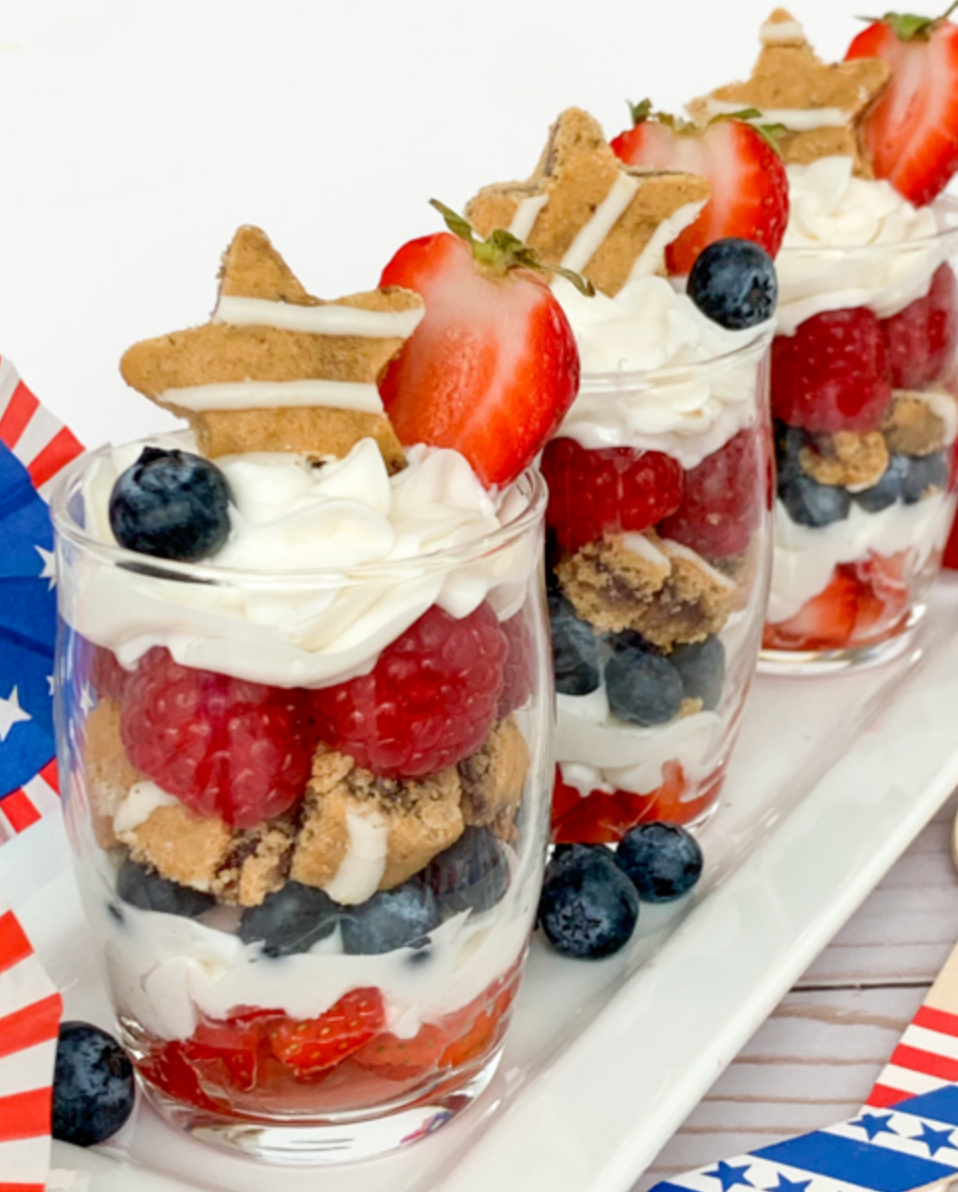 patriotic themed parfaits layered with soft baked bars, yogurt and fresh fruit in tall glasses 