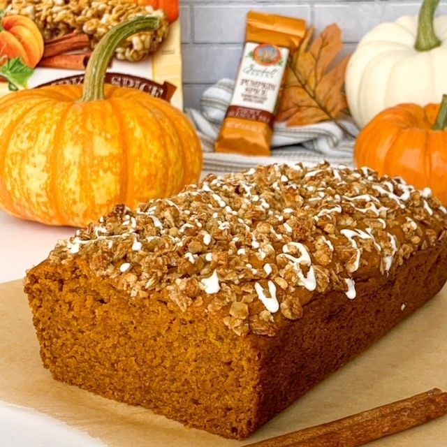 pumpkin spice bread made with granola and topped with granola and drizzle on a fall kitchen background