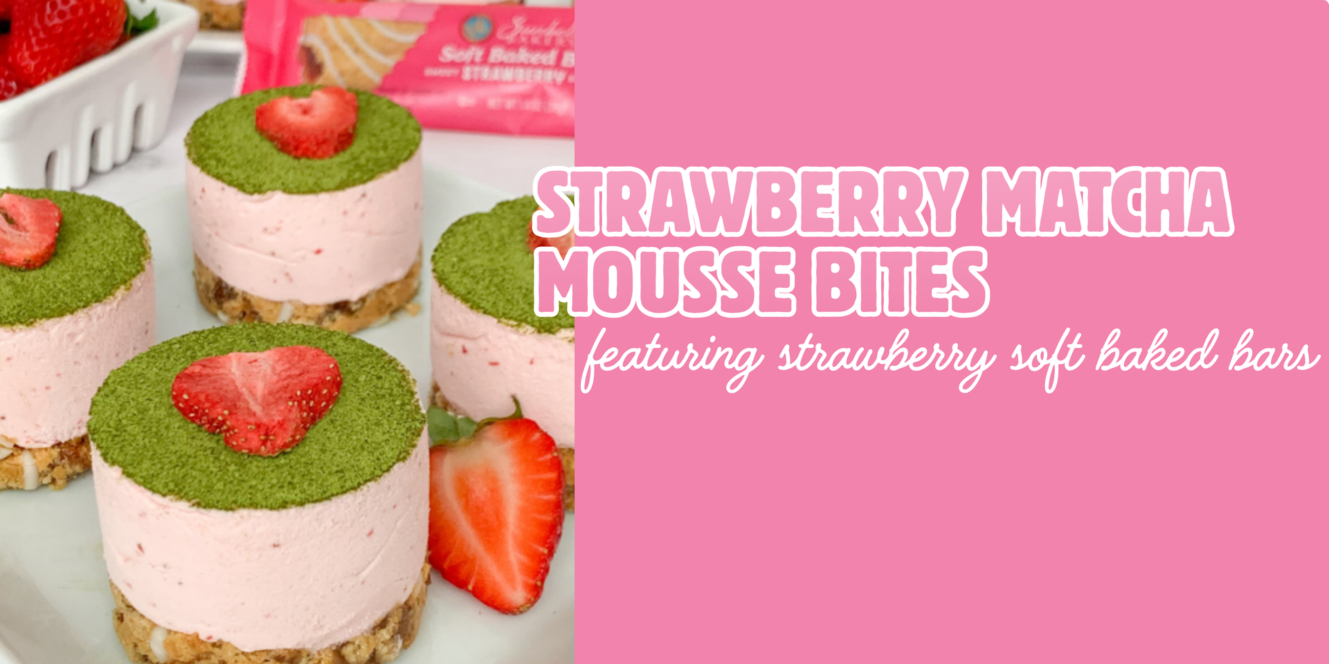 Close-up of four cylindrical strawberry mousse desserts topped with matcha powder and a strawberry slice, sitting on a plate with Sunbelt Bakery packaging in the background.