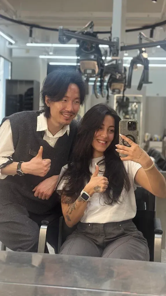 Customers and stylists taking a group selfie inside Soonsiki Moment Hongdae Hair Salon, Seoul