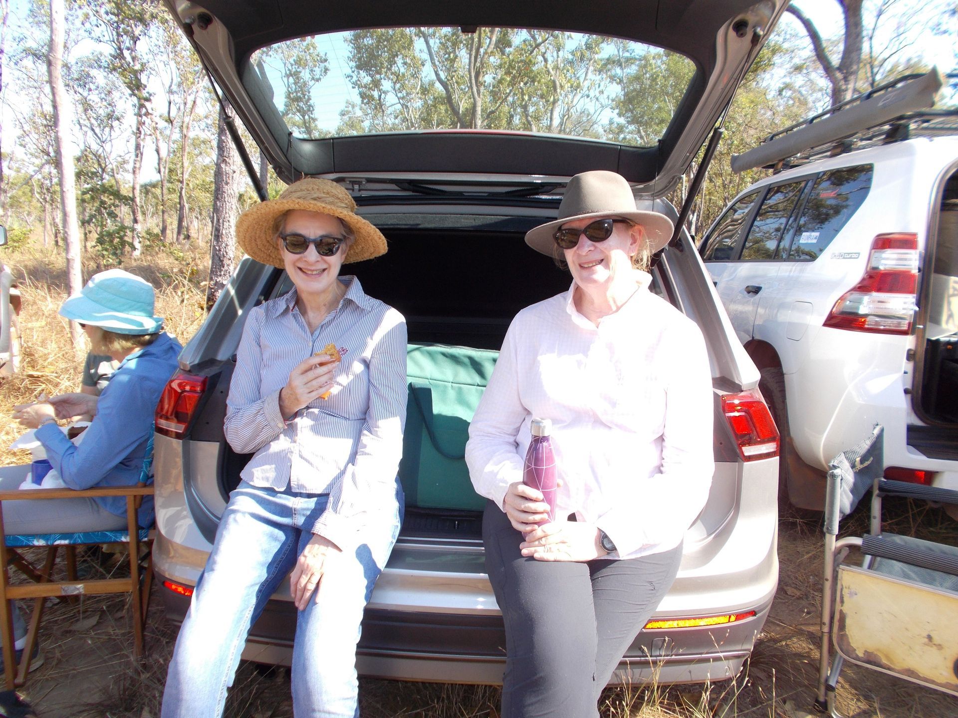 Two women are sitting in the back of a car.