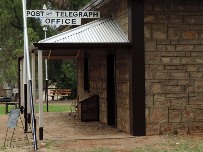 A post and telegraph office is located on the side of a brick building
