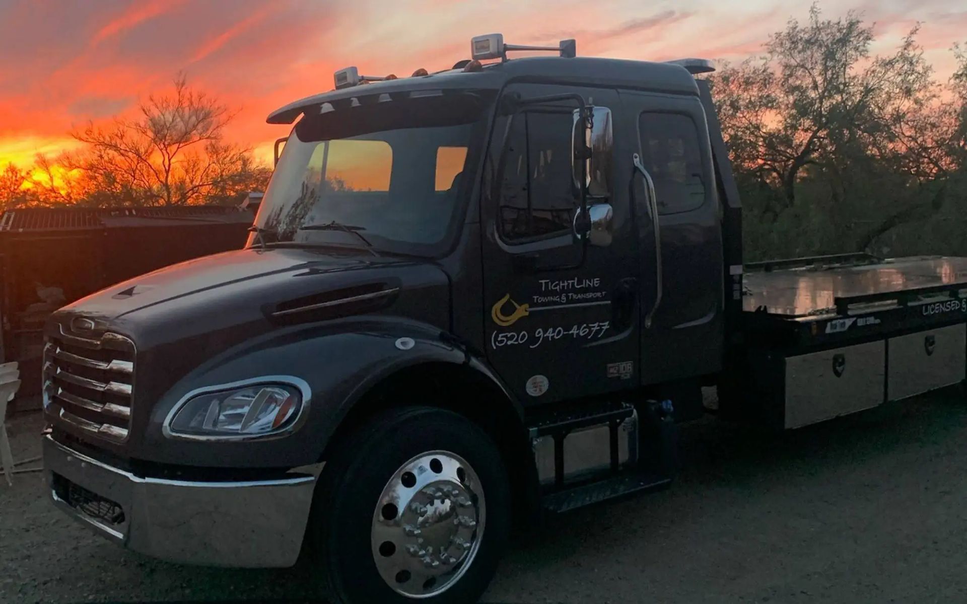 Dark tow truck at sunset.