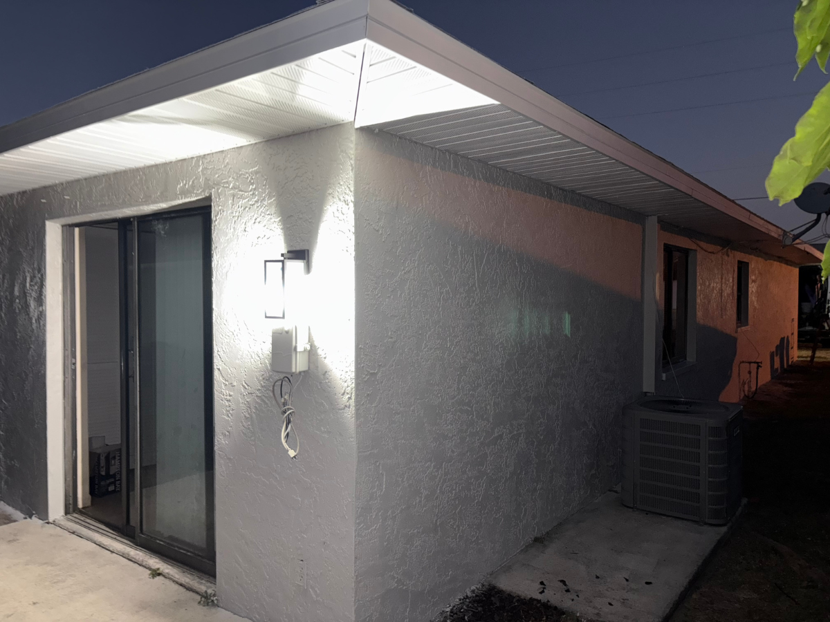 Exterior view of a gray, stucco-walled home at night