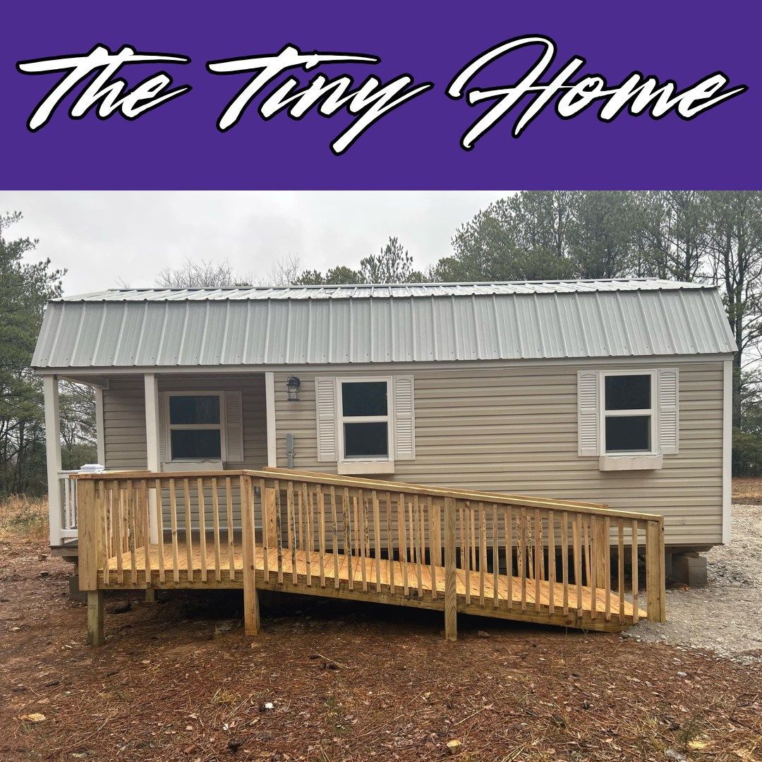 Tiny home with a wooden ramp, tan siding, and metal roof. Text: 