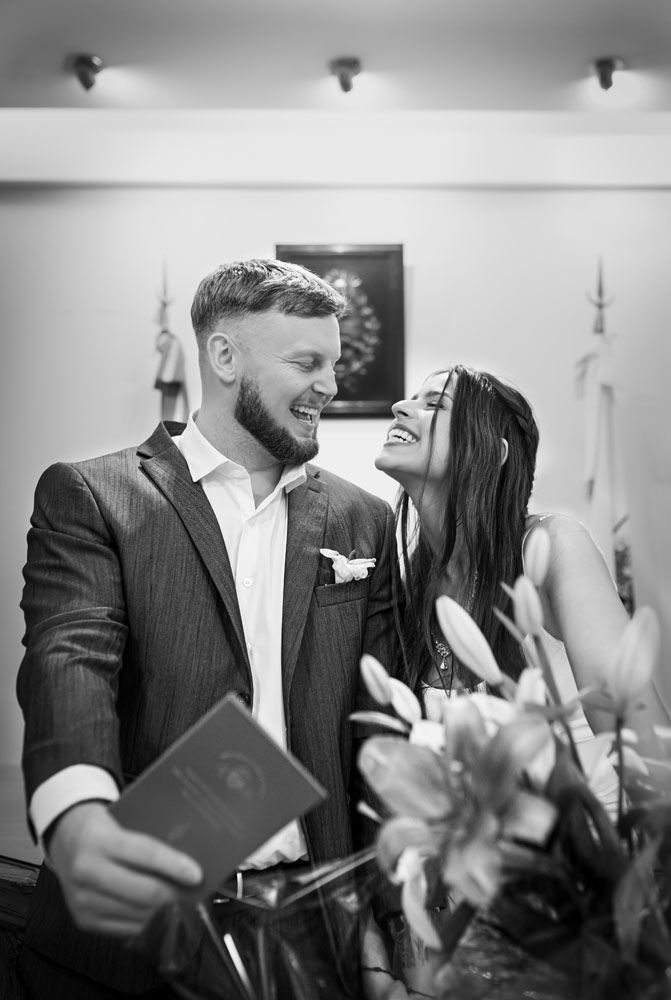 Recién casados en una habitación, sonriéndose.
