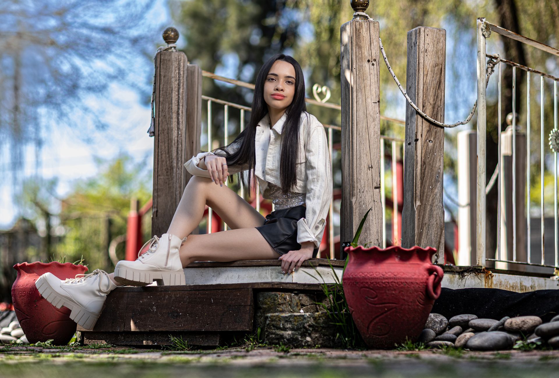 Una mujer se sienta en un puente decorativo en un parque.