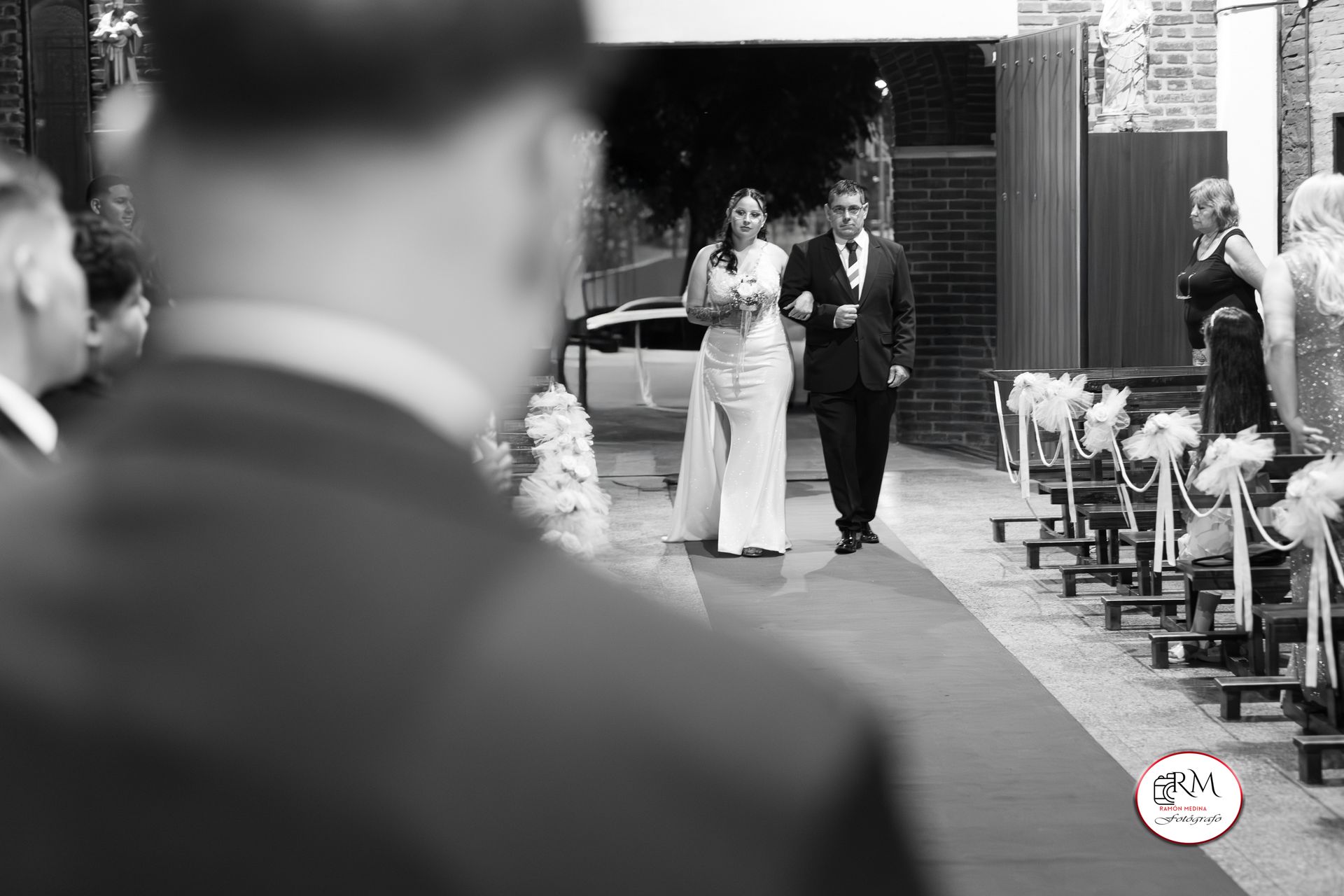 La novia y su acompañante caminan por el pasillo en una boda.