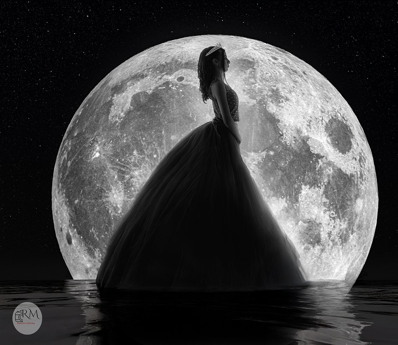 Mujer recortada contra una luna llena, parada en el agua bajo un cielo nocturno estrellado.