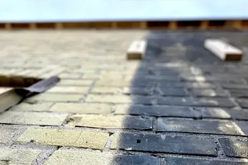 Contact Us A close up of a brick walkway being painted.
