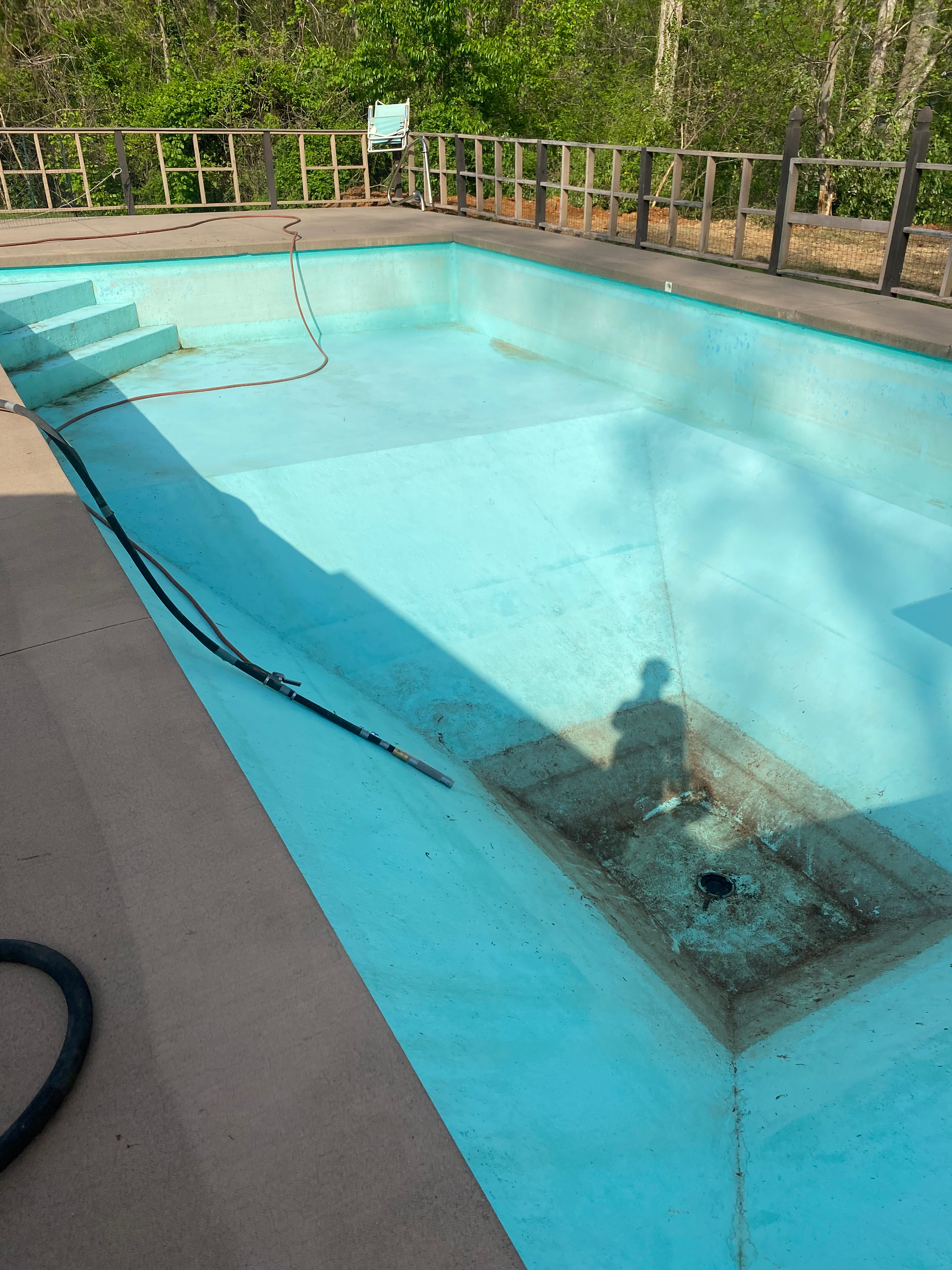 An empty swimming pool with a hose attached to it