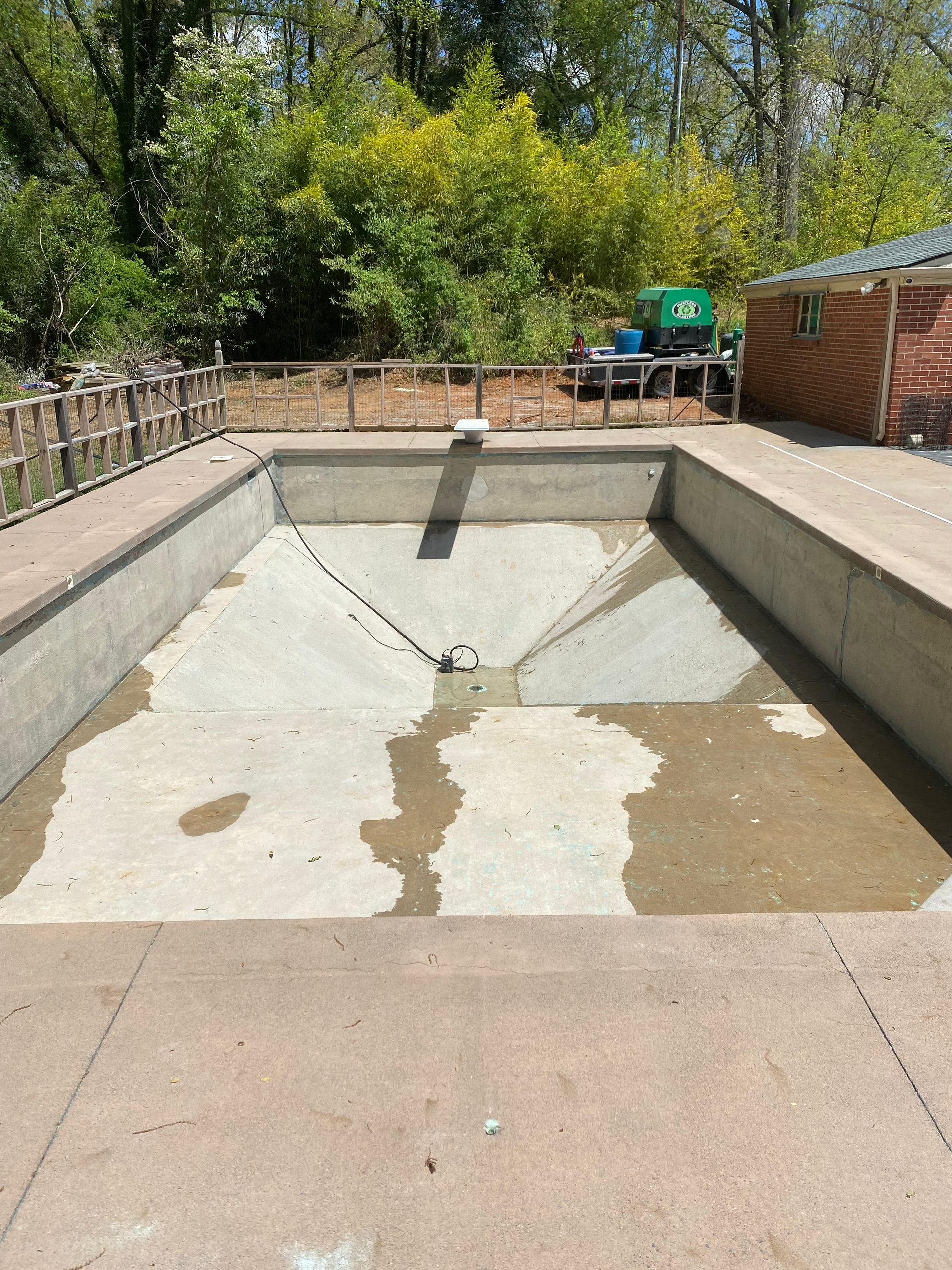 An empty swimming pool with a green truck in the background