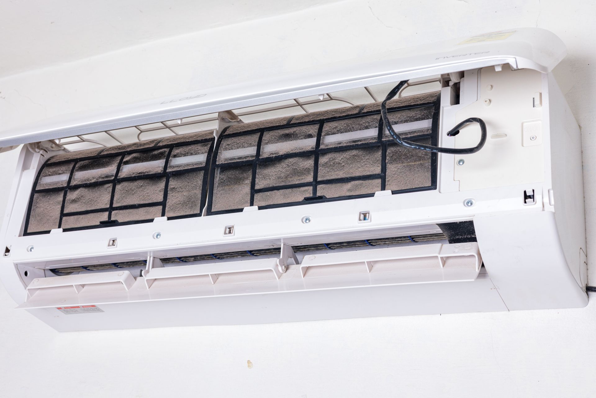 A close up of a dirty air conditioner on a wall. A close up of a dirty air conditioner on a wall.