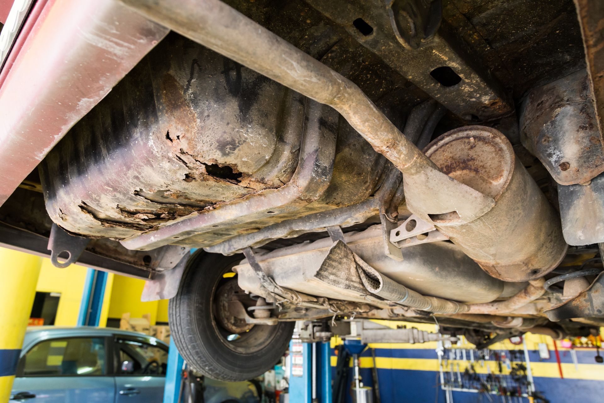 A car is sitting on a lift in a garage.