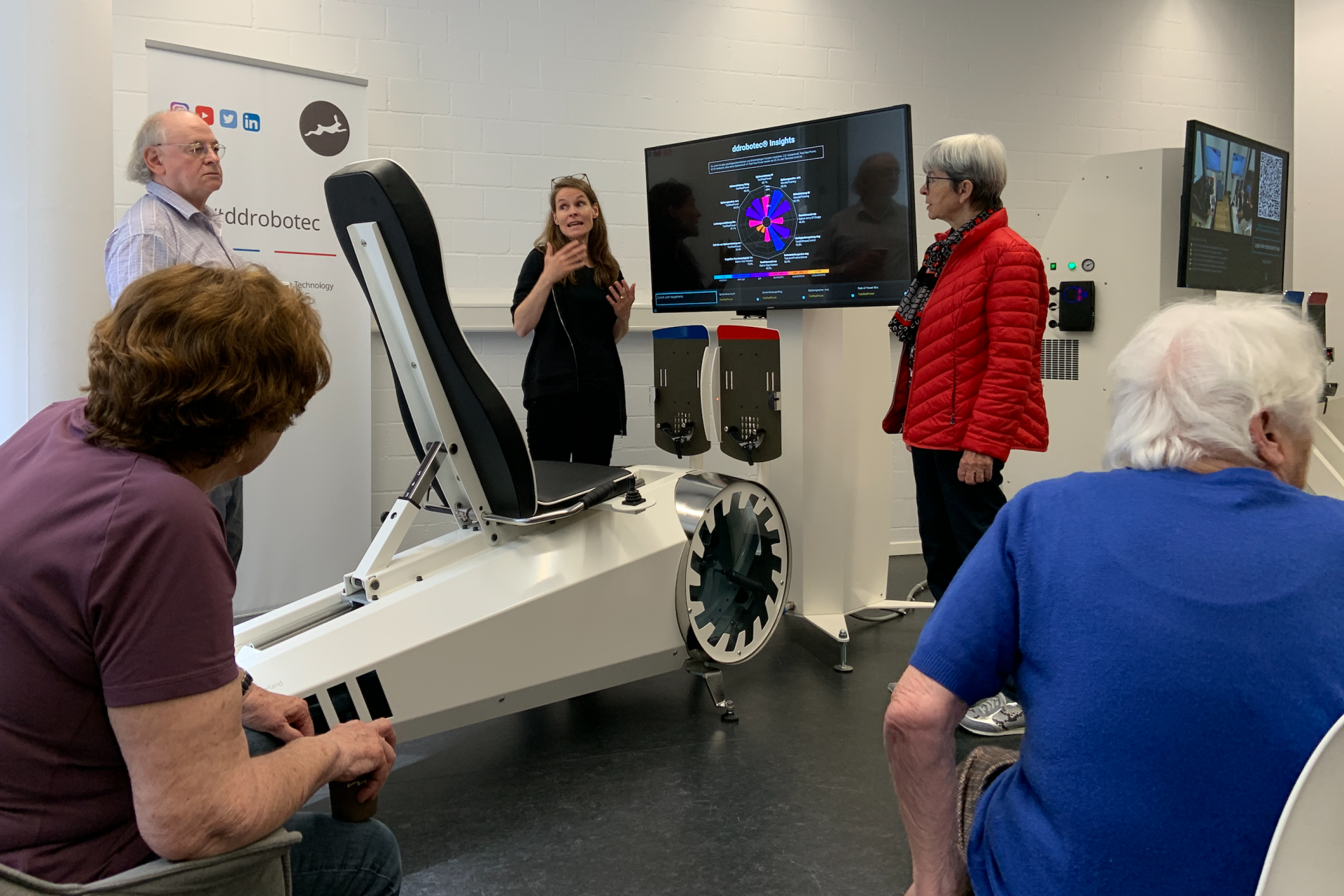 ältere Menschen stehen vor dem robotischen Personal Trainer und konzentrieren sich auf den Vortrag.