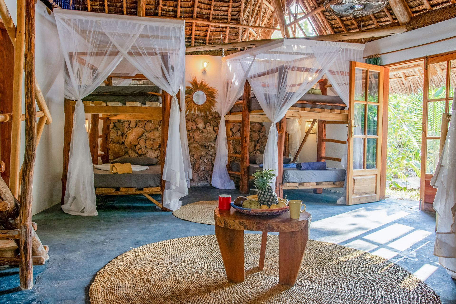 A bedroom with a canopy bed and a wooden table.