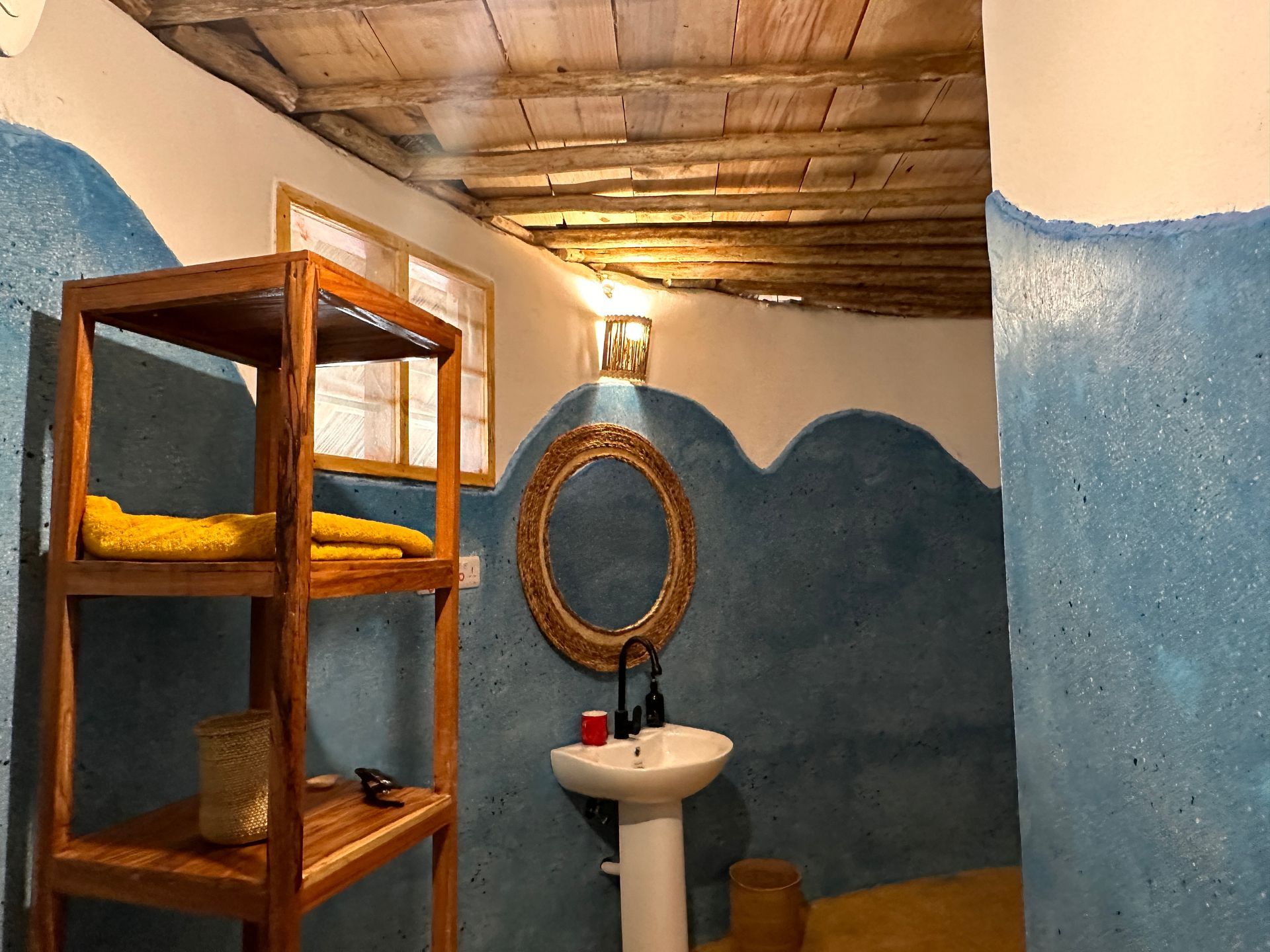 A bathroom with a sink , mirror and shelves