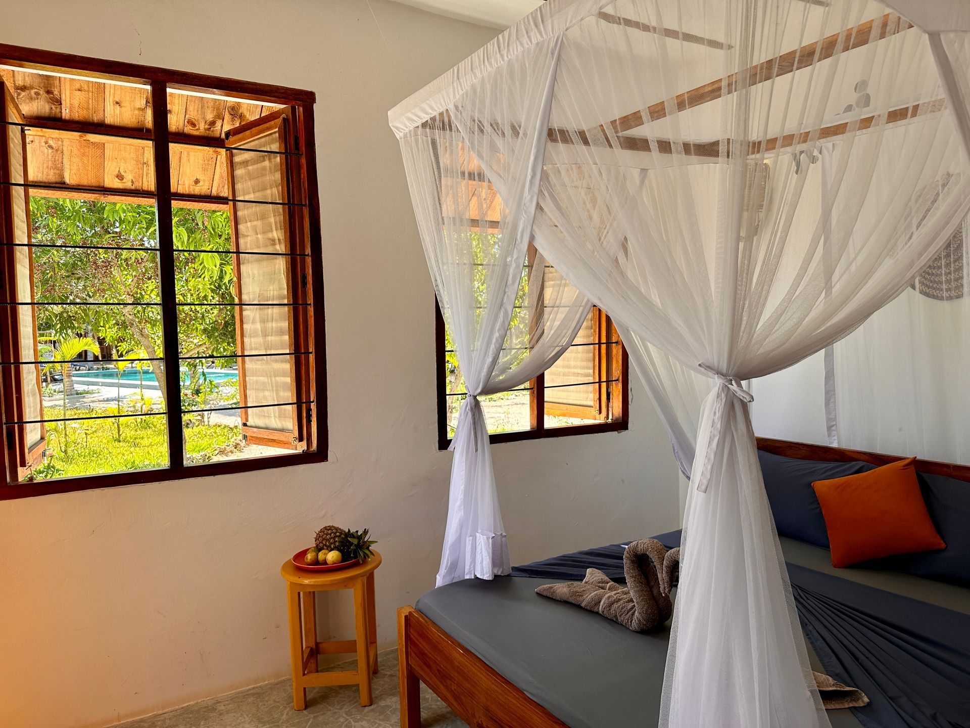A bedroom with a canopy bed and a window