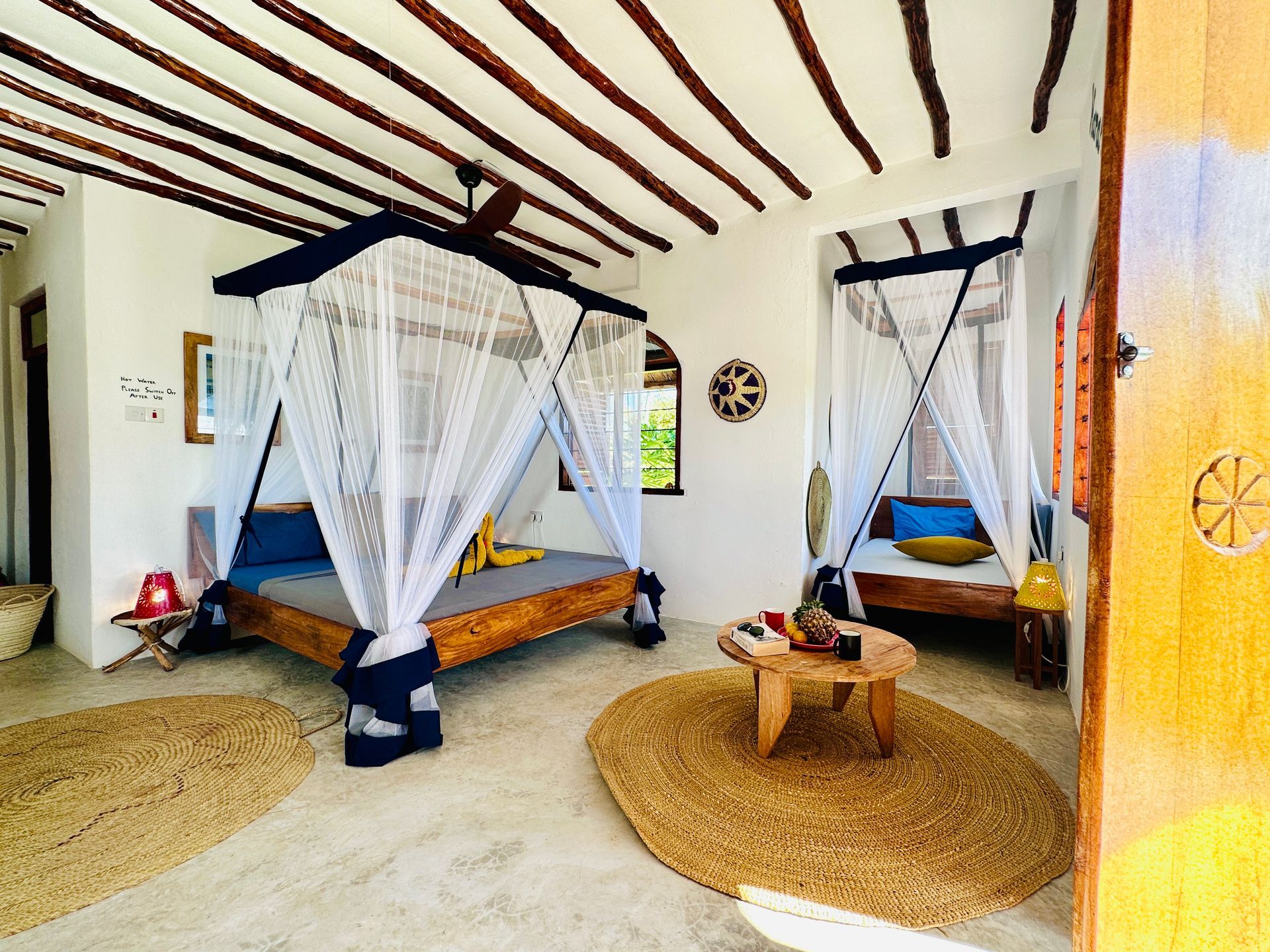 There are two beds in the room with mosquito nets.
