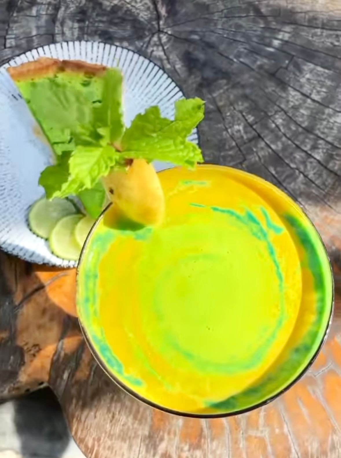 A green and yellow plate with a piece of fruit on top of it.